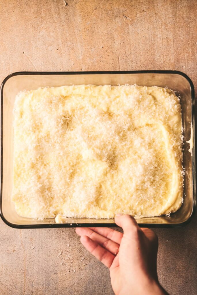 The potatoes, in a baking pan, with parmesan on top. 
