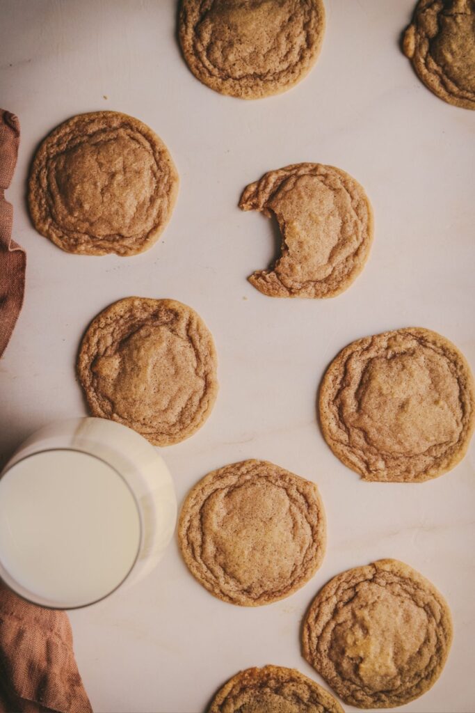 A batch of chocolate chipless cookies with a glass of milk. 