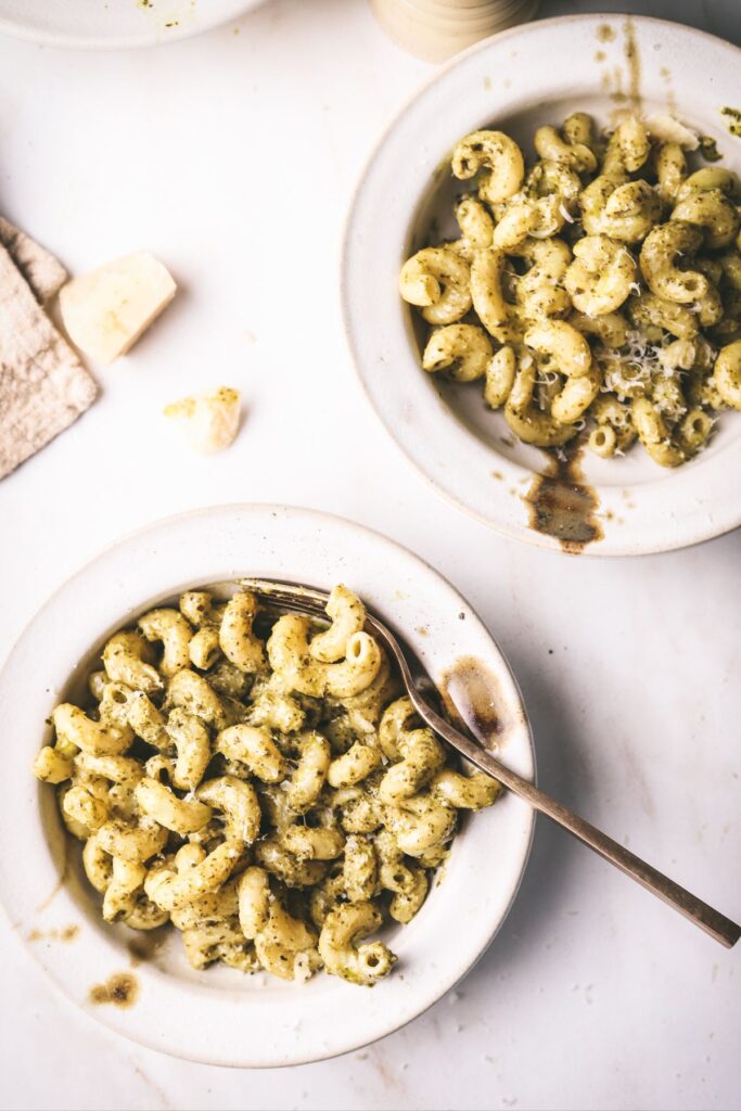 Two bowls of pasta with creamy pesto sauce. 