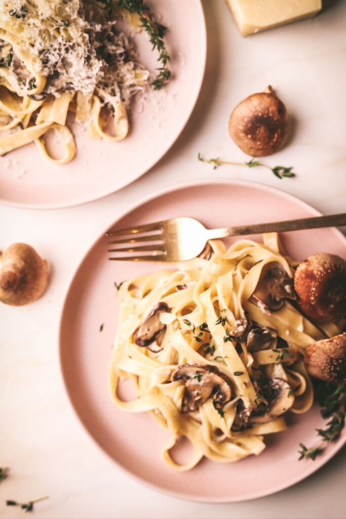 Creamy mushroom pasta sauce with shiitake mushrooms and gold fork. 