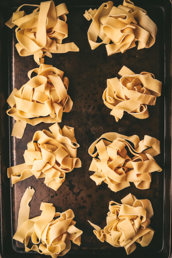 Pappardelle nests on a baking sheet, single layer, ready to hit the freezer. 