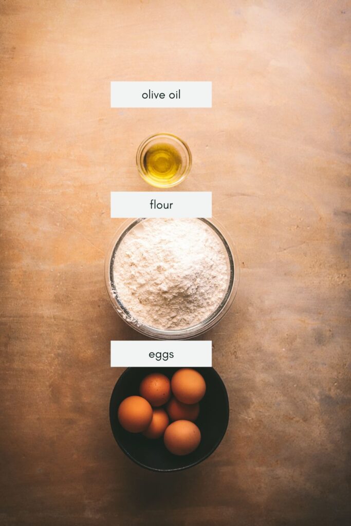 The three ingredients for homemade pasta, eggs, oil, and flour. 