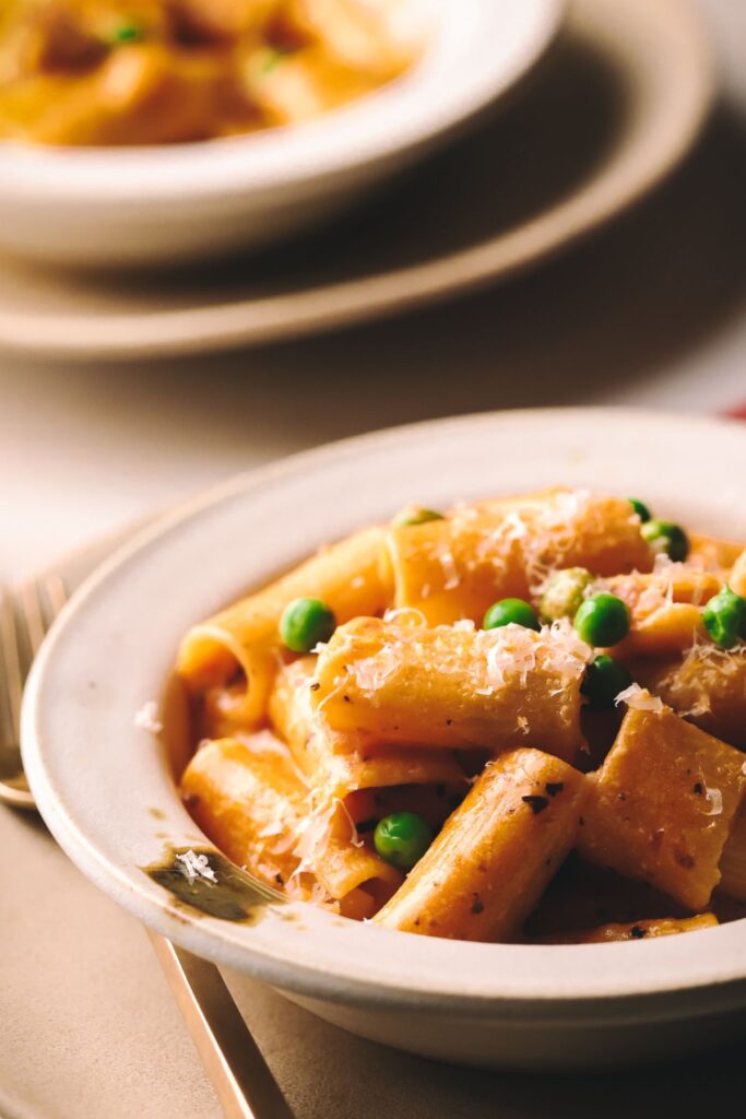 Rigatoni pasta with pancetta and peas in a blush sauce. 