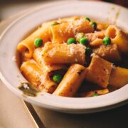 Pasta with pancetta and peas in a bowl.