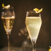 Two french 75 cocktails garnished with lemon.