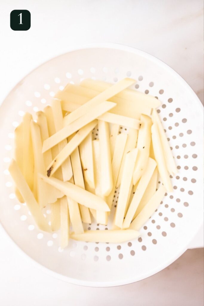 French fries, peeled and cut in a colander.