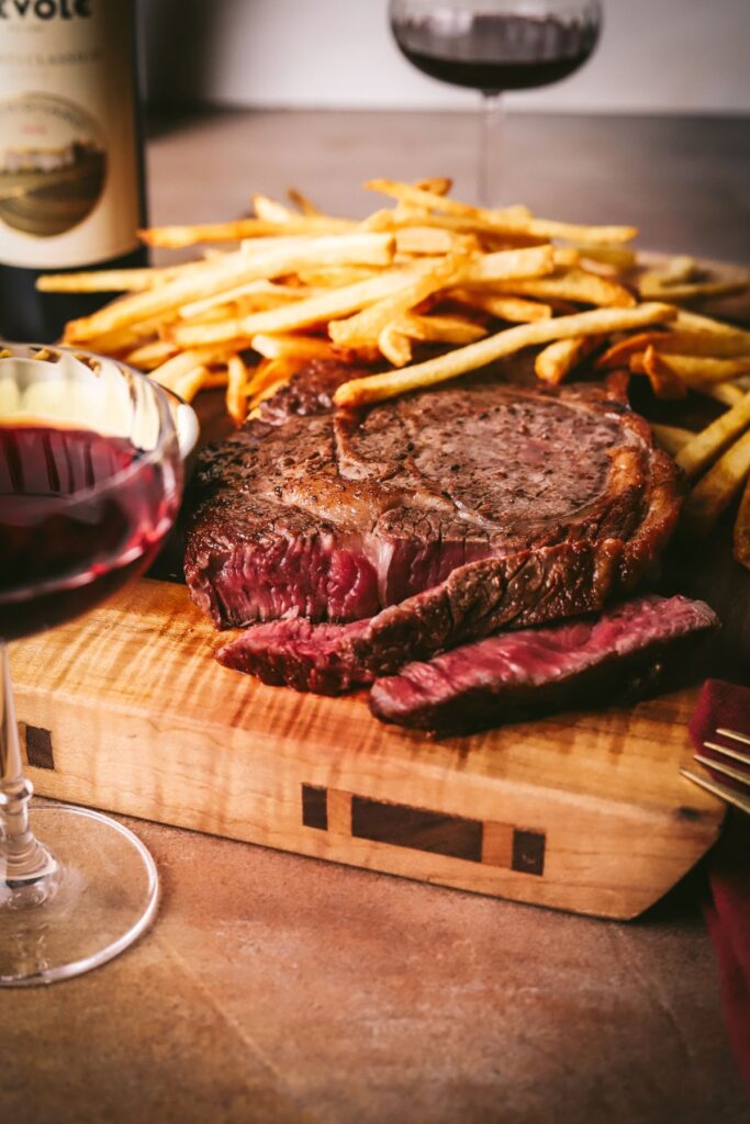 A rare steak, crispy French fries, and red wine. 