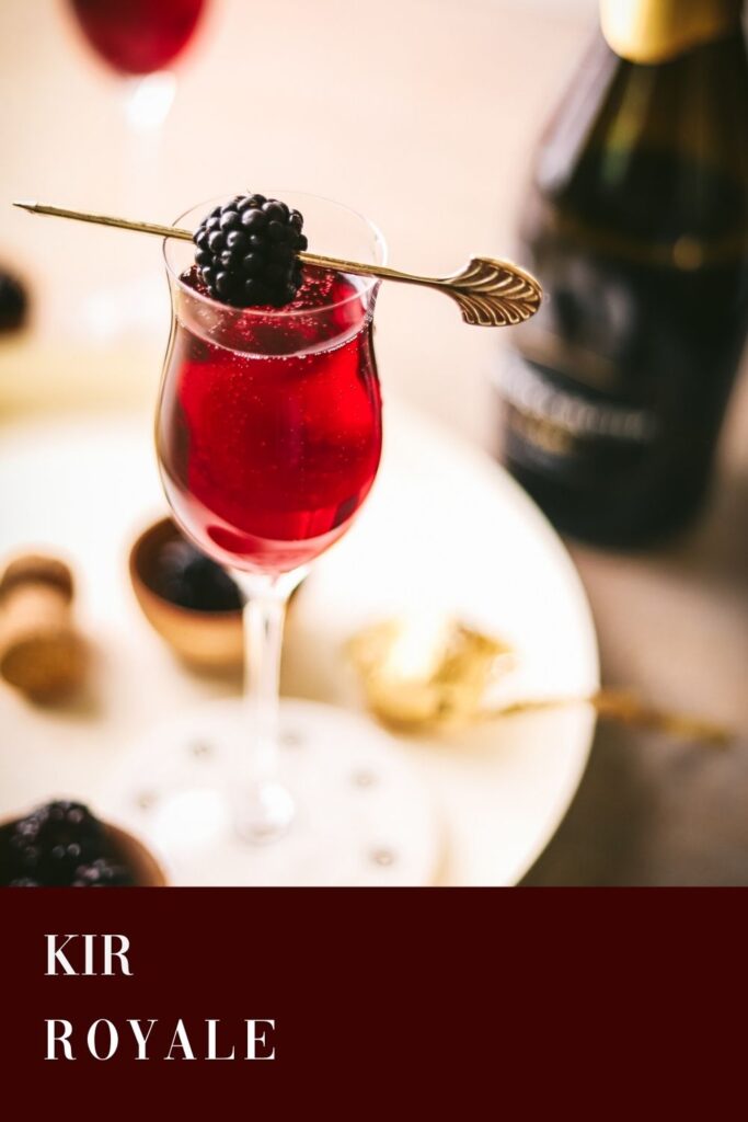 A Kir Royale cocktail with blackberry garnish.