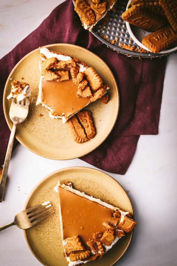 Several slices of no-bake cookie butter cheesecake with a forkful and a purple napkin.