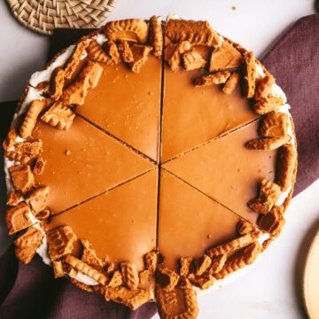 A full Biscoff cheesecake (no-bake, speculoos) sliced into six, with a purple napkin.