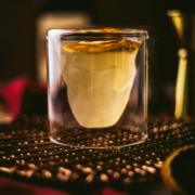 A corpse reviver cocktail in a skull glass and citrus on top.