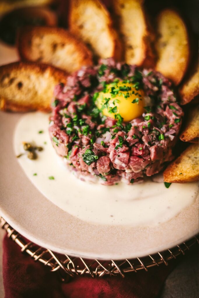 Steak tartare with aioli and toasted baguette slices. 