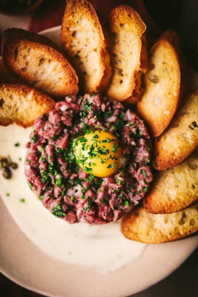 Steak tartare with herbs and toasted baguette slices. 