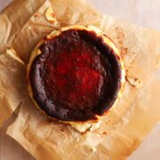 A full burnt Basque cheesecake on parchment paper.